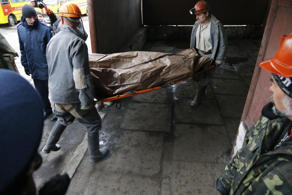 Ukrainian rescuers carry a stretcher with a gas explosion victim's body at the Skochinsky mine in Donetsk, Ukraine, Friday, April 11, 2014. Several people were killed in a gas explosion at a coal mine in eastern Ukraine on Friday, officials said. The Emergency Services Ministry said Seventy-eight people were working in the mine when the blast occurred early Friday morning. They said it was provoked by a sudden release of gas during work in the drilling pits. 13 rescue teams and five resuscitation and anti-shock teams were dispatched to the scene of the accident, officials said. (AP Photo/Andrey Basevich)