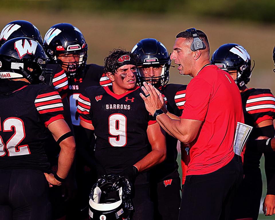 Woodbridge High School football coach Joe LaSala stresses to his players the importance of supporting one another and giving back.