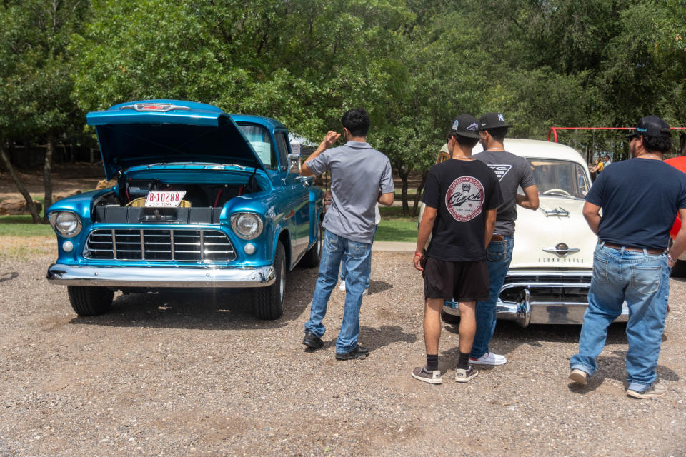 A group looks over classic cars  Saturday at Friona's 17th annual Cheeseburger Festival.
