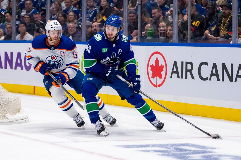 Edmonton Oilers forward Connor McDavid (97) defends against Vancouver Canucks defenseman Quinn Hughes (43) during the first period in game five of the second round of the 2024 Stanley Cup Playoffs at Rogers Arena.