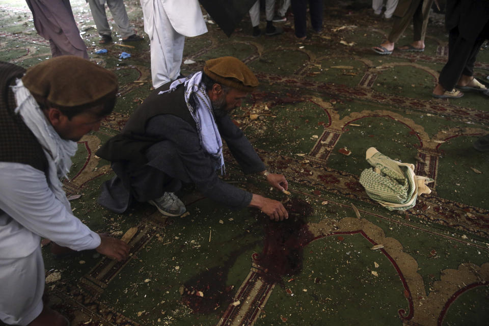 Afghans clean blood stains the inside a mosque following a bombing, in Kabul, Afghanistan, Friday, June 12, 2020. (AP Photo/Rahmat Gul)