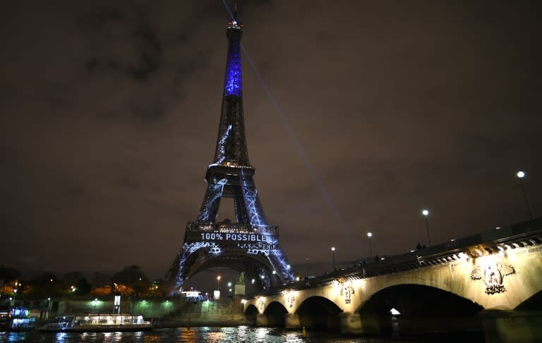 The Eiffel Tower is illuminated with messages against global warming during the first day of the United Nations climate conference in Paris on November 30, 2015