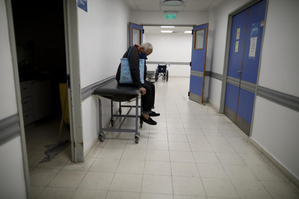 A man sits in a corridor as he waits for news of his wife who is a suspected COVID-19 case at Llavallol Dr. Norberto Raúl Piacentini Hospital in Lomas de Zamora, Argentina, Saturday, May 1, 2021. The man's wife was intubated and a few days later passed away. (AP Photo/Natacha Pisarenko)