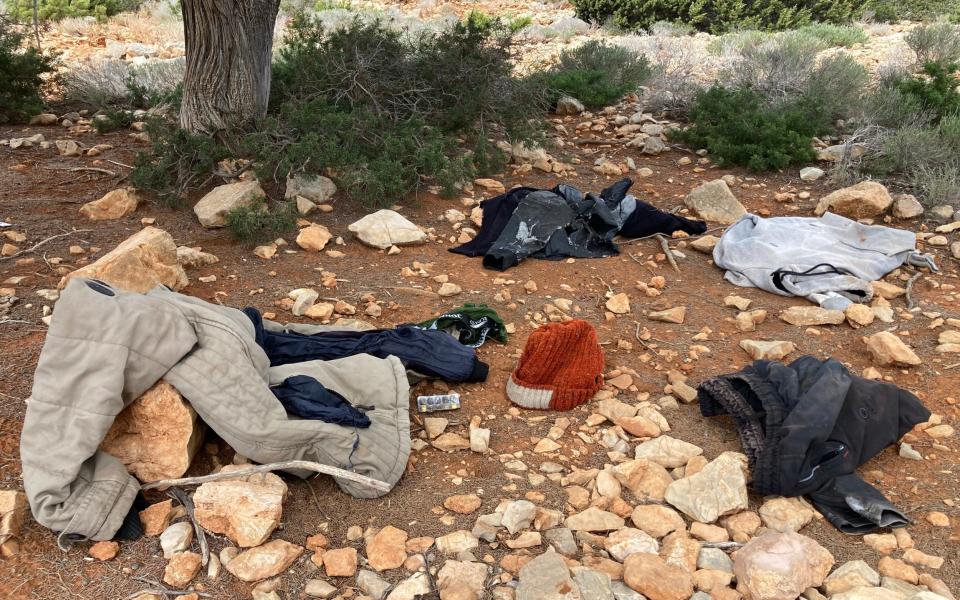 Clothes and other belongings are abandoned on the road frequented by migrants heading to Tripiti beach in Gavdos.