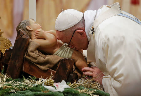 Pope Francis kisses the statue of baby Jesus as he arrives to lead a mass to mark the World Day of Peace in Saint Peter's Basilica at the Vatican January 1, 2018. REUTERS/Max Rossi