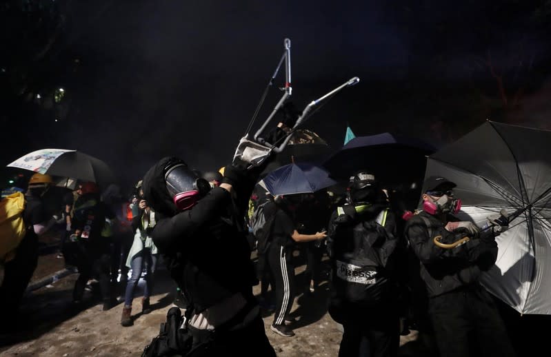 A protester uses a slingshot during a standoff with riot police at the Chinese University of Hong Kong