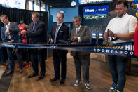 From left, Caesars Sports & Online Gaming Co-President Eric Hession, CEO of Caesars Entertainment CEO Tom Reeg, Monumental Sports & Entertainment Business Operations & Chief Commercial Officer President Jim Van Stone, Founder & CEO of Monumental Sports & Entertainment and owner of the Washington Wizards and the Washington Capitals Ted Leonsis, and chef Nicholas Stefanelli participate in a ribbon cutting for the William Hill Sportsbook at Monumental Sports & Entertainment's Capital One Arena in Washington, Wednesday, May 26, 2021. The William Hill Sportsbook is the first ever sports betting venue to open within a U.S. professional sports facility. (AP Photo/Andrew Harnik)