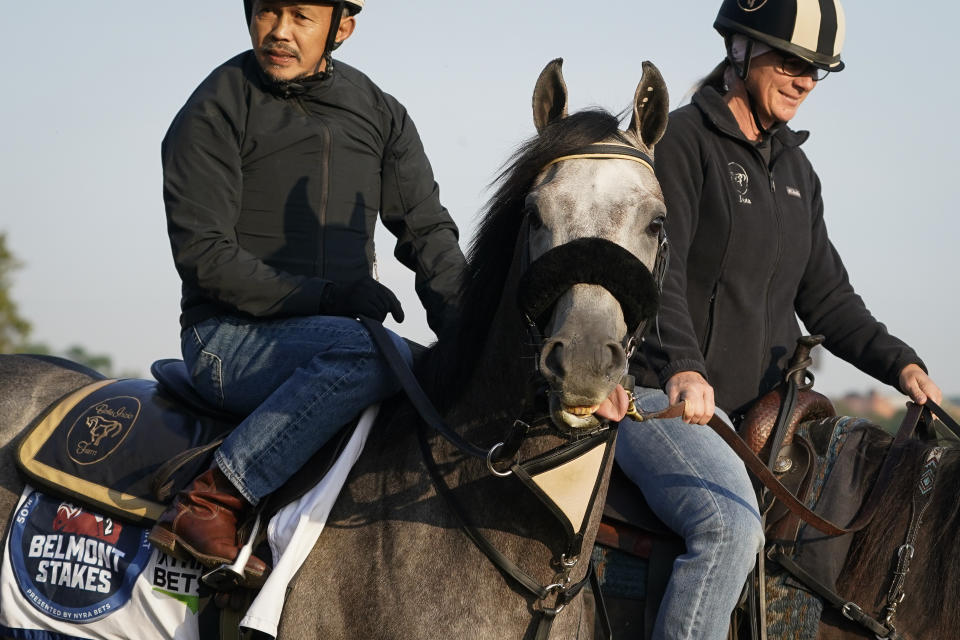 Arcangelo, left, and trainer Jena Antonucci, right, walk along the track before training ahead of the Belmont Stakes horse race, Friday, June 9, 2023, at Belmont Park in Elmont, N.Y. (AP Photo/John Minchillo)