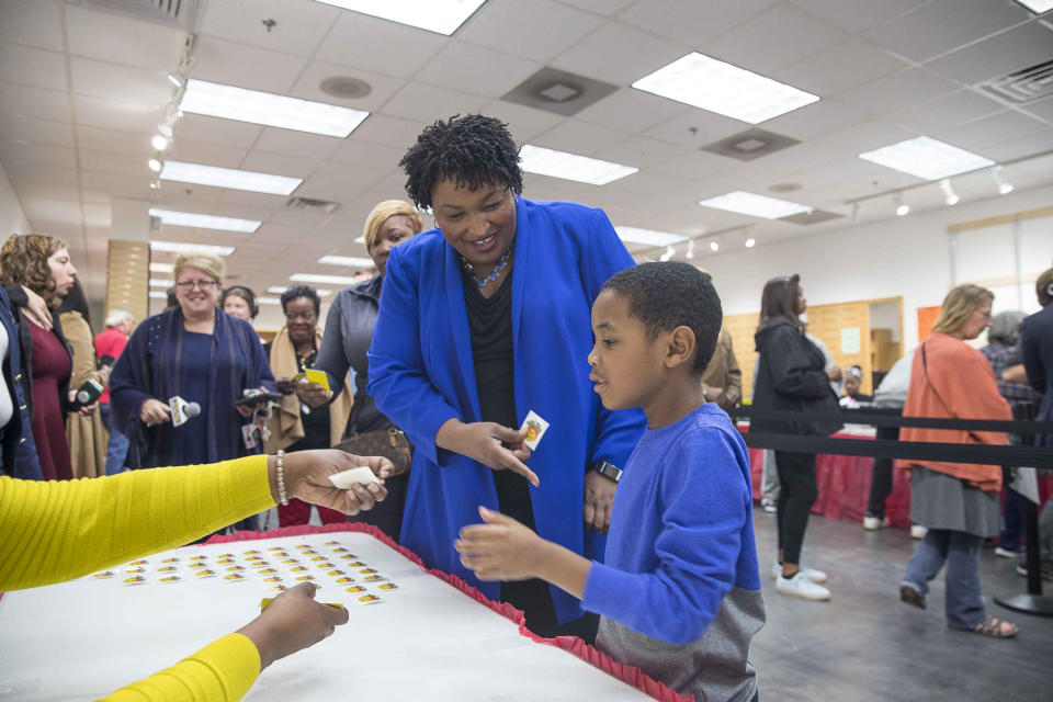 Georgia gubernatorial candidate Stacey Abrams receives a voting sticker with her nephew, Cameron McLean, after casting her ballot during early voting at The Gallery at South DeKalb Mall in Decatur, Monday, October 22, 2018. Today marks only 15 days left until Election Day on Tuesday, November 6. (Alyssa Pointer/Atlanta Journal-Constitution via AP)