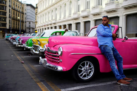 Driver Giovani Bernati waits for tourists beside vintage cars used as taxi in Havana, Cuba, October 5, 2018. Picture taken October 5, 2018. REUTERS/Alexandre Meneghini