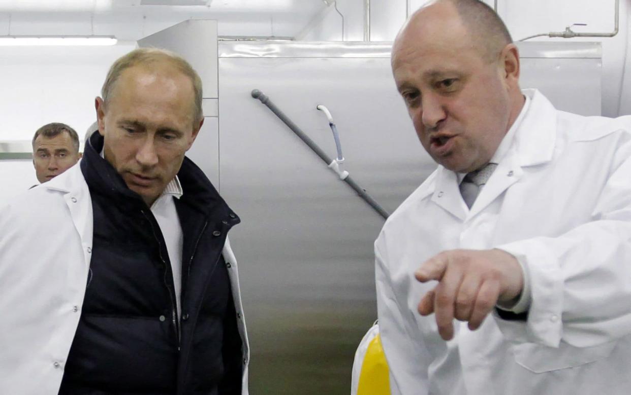 Yevgeny Prigozhin shows Vladimir Putin a school lunch factory near St Petersburg - AFP/ALEXEY DRUZHININ 