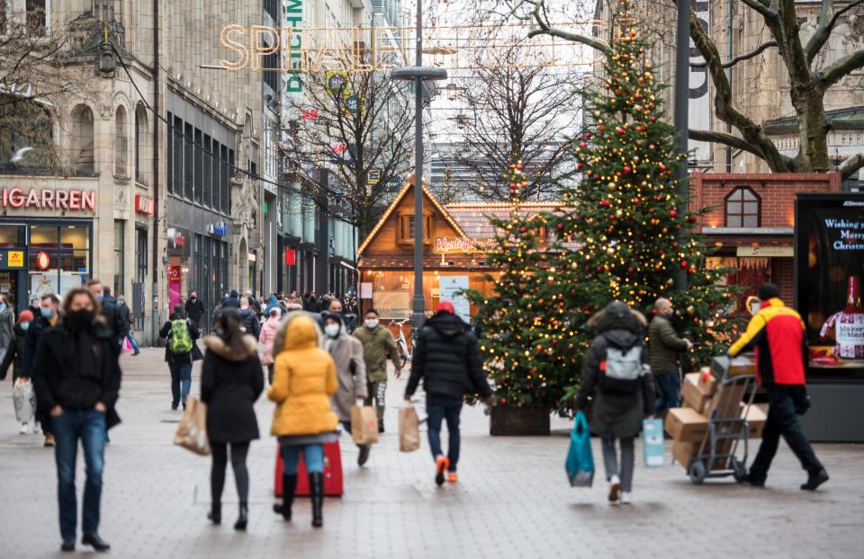 14 December 2020, Hamburg: Passers with nose-mouth-guards walk through the Christmassy decorated shopping street "Spitalerstraße" in the city centre. From 16.12.2020, Hamburg is stepping up its measures to contain the corona pandemic in view of the continuing high infection figures. Photo: Daniel Bockwoldt/dpa (Photo by Daniel Bockwoldt/picture alliance via Getty Images)