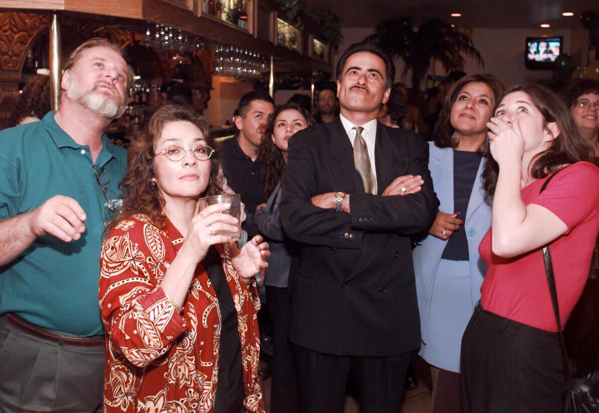 Richard Alarcon and others look up at a TV screen