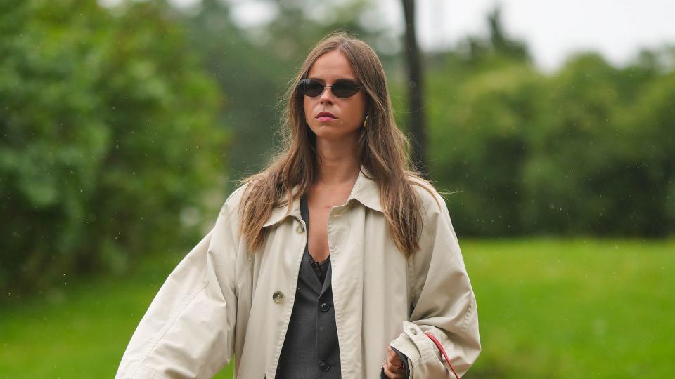 Woman wearing a trench coat with red accessories 