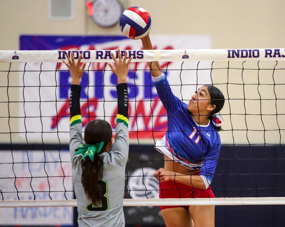Indio's Joselin Martinez (11) hits over Coachella Valley's Mia Villalobos (3) during the first set of their match in Indio, Calif., Tuesday, Sept. 19, 2023.