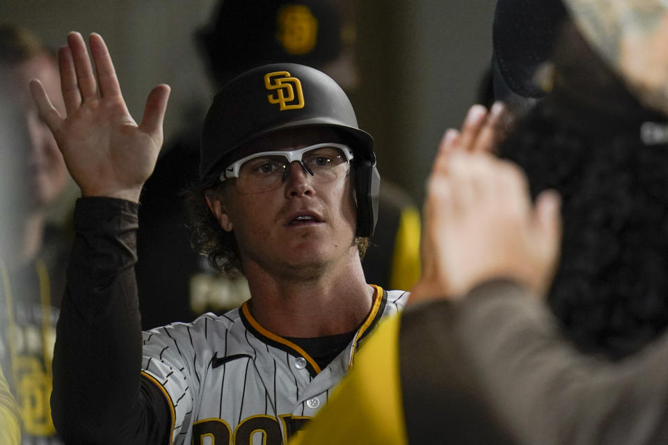 San Diego Padres' Brandon Dixon, right, celebrates with teammates after scoring off a walk with the bases loaded by Josh Bell during the eighth inning of a baseball game against the San Francisco Giants, Monday, Oct. 3, 2022, in San Diego. (AP Photo/Gregory Bull)