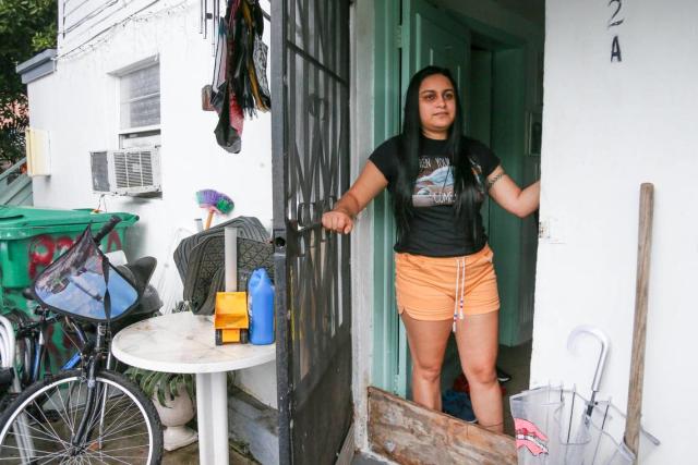 Gabriela Murillo, que vive con sus padres en Southwest Third Street, mira desde la puerta de su casa una semana después de que su casa de alquiler se inundara debido a un fin de semana de fuertes lluvias en el barrio de La Pequeña Habana en Miami, Florida, el viernes 10 de junio de 2022.