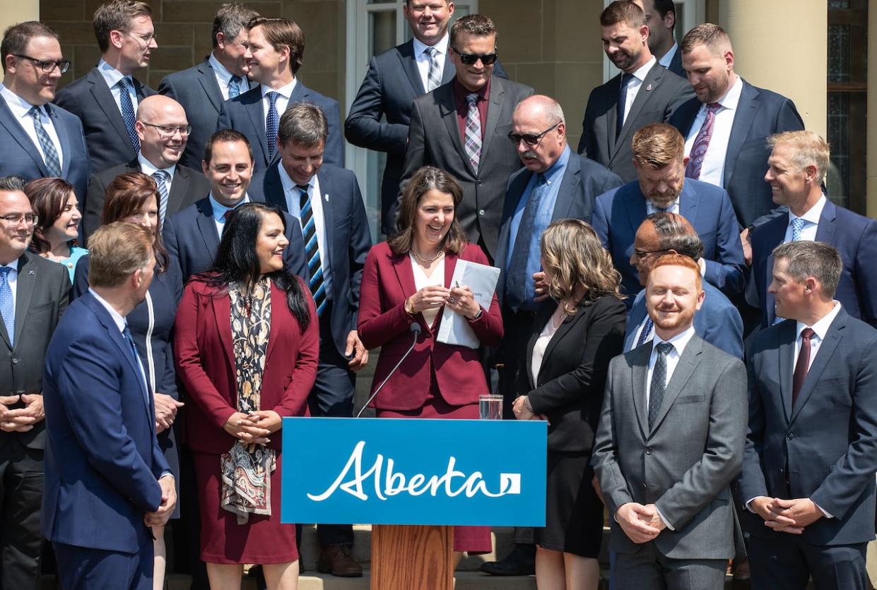 Premier Danielle Smith greets her Alberta cabinet on the day they were sworn in last June. (Jason Franson/The Canadian Press - image credit)