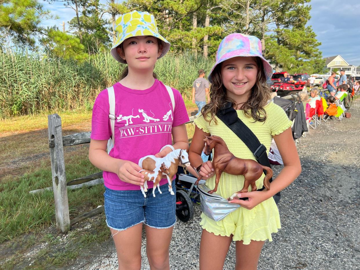 Grace Jackson and Veruca Schweiger, both 10, of WIlmington, Delaware, show off their plastic horses while waiting for the Chincoteague Pony Swim 2022 on Wednesday, July 27. The girls are members of the Wilmington Hobby Horse Club.