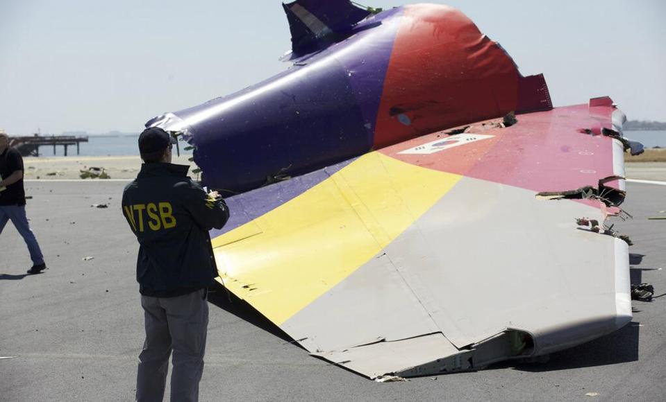 A National Transportation Safety Board (NTSB) investigator looks at the tail section of the Asiana Airlines Flight 214 that crashed at San Francisco International Airport in San Francisco, California in this handout file photo released on July 7, 2013. Pilots of the Asiana Airlines Inc plane were aware the plane was traveling too slowly and tried to correct it in the final seconds before impact, according to documents released on December 11, 2013 by U.S. aviation safety investigators. (REUTERS/NTSB/Handout via Reuters)