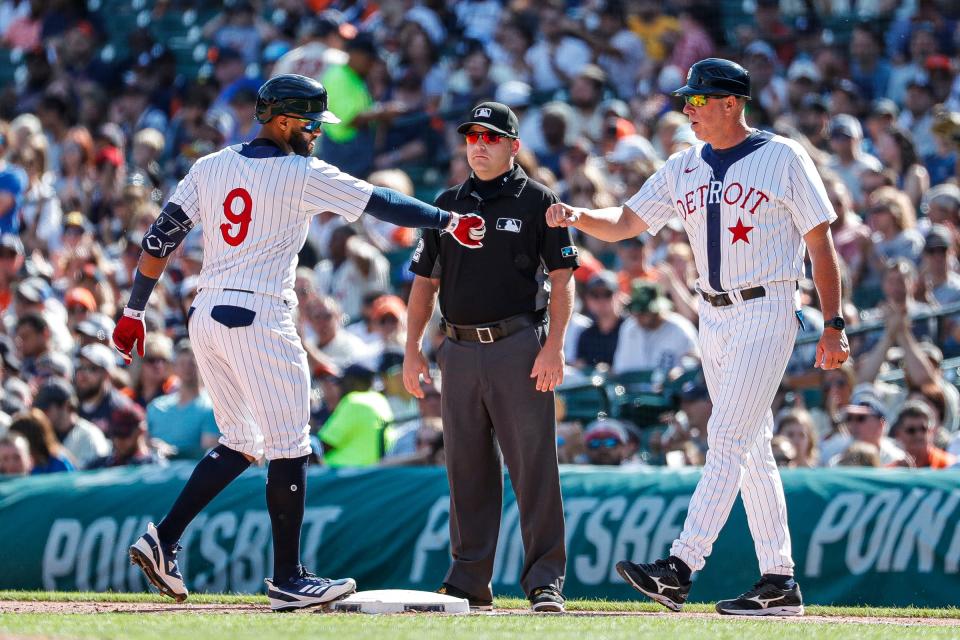 Detroit Tigers right fielder Willi Castro (9) fist-bumps first base coach Mike Hessman after hitting a single against the Texas Rangers during the fourth inning at Comerica Park in Detroit on Saturday, June 18, 2022.
