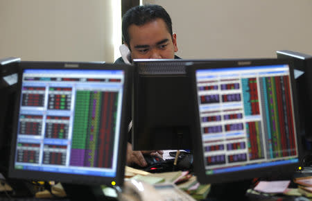 An Indonesian broker speaks on his phone while monitoring the share price at Bank Mandiri Sekuritas trading floor in Jakarta August 19, 2011. REUTERS/Supri/Files