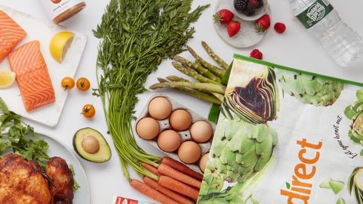 freshdirect bag with a variety of groceries on a white countertop