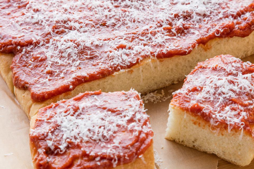 Cut-up tomato pie on a wooden board