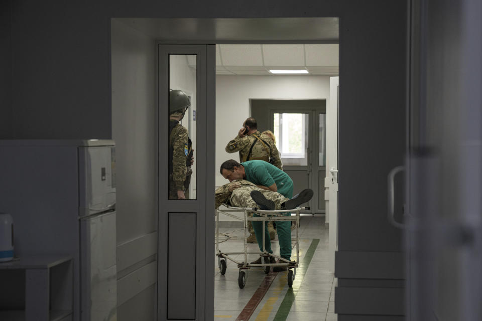A doctor treats a Ukrainian serviceman injured inside the hospital after an attack by Russian forces in the Donetsk region, Ukraine, on Monday, May 9, 2022.(AP Photo/Evgeniy Maloletka)