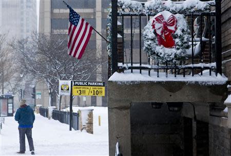 A person walks down a snow-covered sidewalk, as a winter storm moves across the midwest, in Milwaukee, Wisconsin December, 22, 2013. REUTERS/Darren Hauck