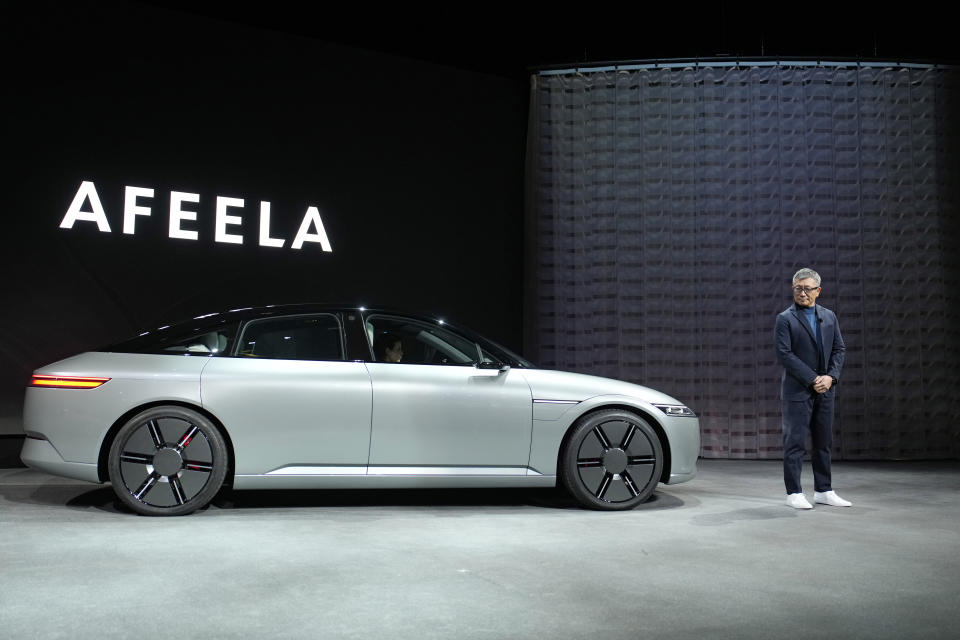 Yasuhide Mizuno, representative director, chairman and CEO of Sony Honda Mobility Inc. stands beside a newly unveiled electric vehicle prototype car Afeela, a joint venture between Sony and Honda, during a Sony news conference before the start of the CES tech show Wednesday, Jan. 4, 2023, in Las Vegas. (AP Photo/John Locher)