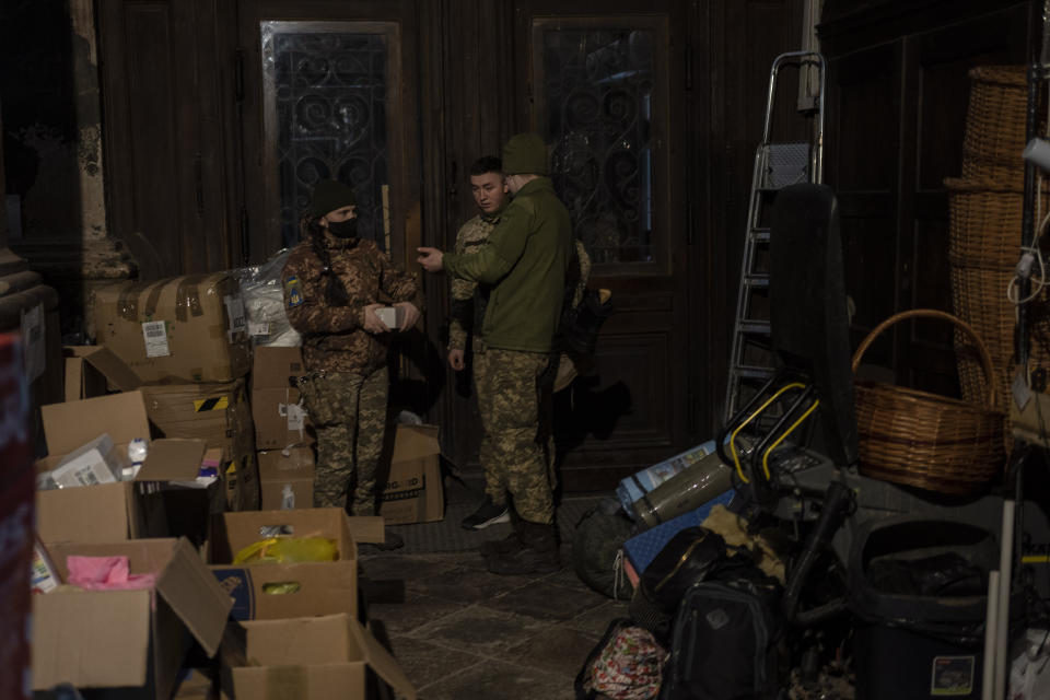 Ukrainians dressed in military attire talk inside the Saints Peter and Paul Garrison Church in Lviv, western Ukraine, Sunday, March 6, 2022. (AP Photo/Bernat Armangue)