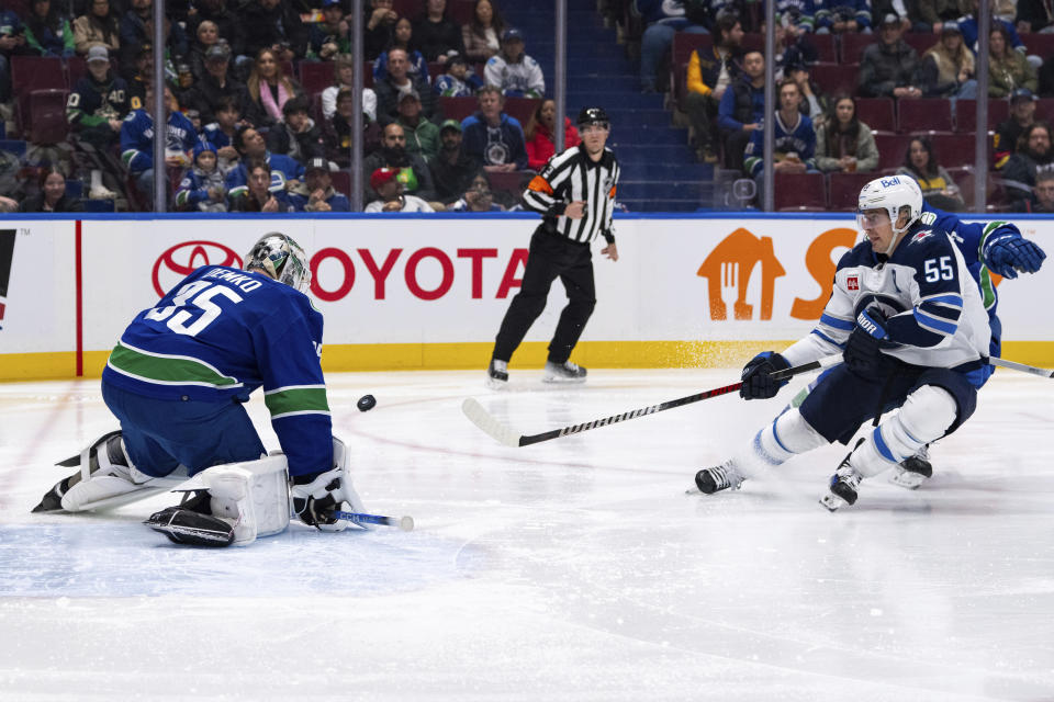 Vancouver Canucks goaltender Thatcher Demko (35) stops Winnipeg Jets' Mark Scheifele (55) as Vancouver's Carson Soucy (7) watches during the second period of an NHL hockey game Saturday, March 9, 2024, in Vancouver, British Columbia. (Ethan Cairns/The Canadian Press via AP)