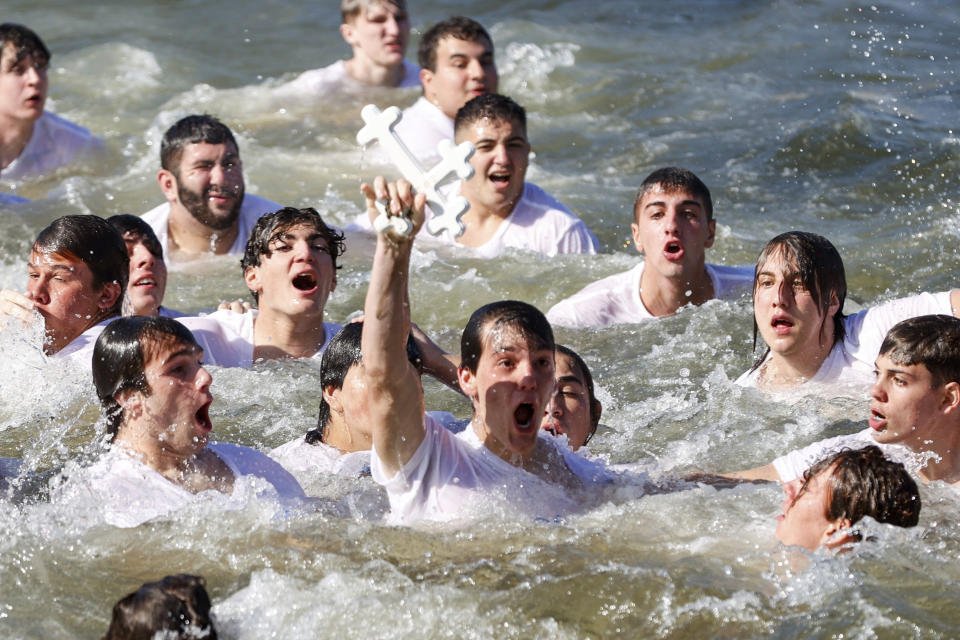 John Hittos, 16, retrieves the cross during the annual cross dive in the Spring Bayou, part of the Epiphany celebration on Saturday, Jan. 6, 2024, in Tarpon Springs, Fla. (Jefferee Woo/Tampa Bay Times via AP)