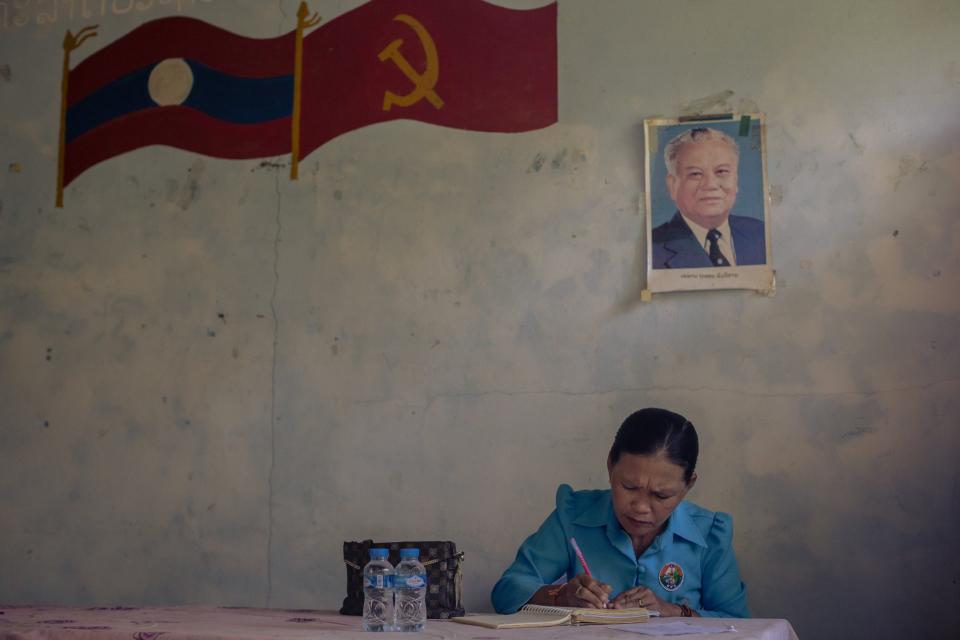 Khoa Village Chief Douavonh Xaythalar, 54 makes notes in at the village hall in Laos