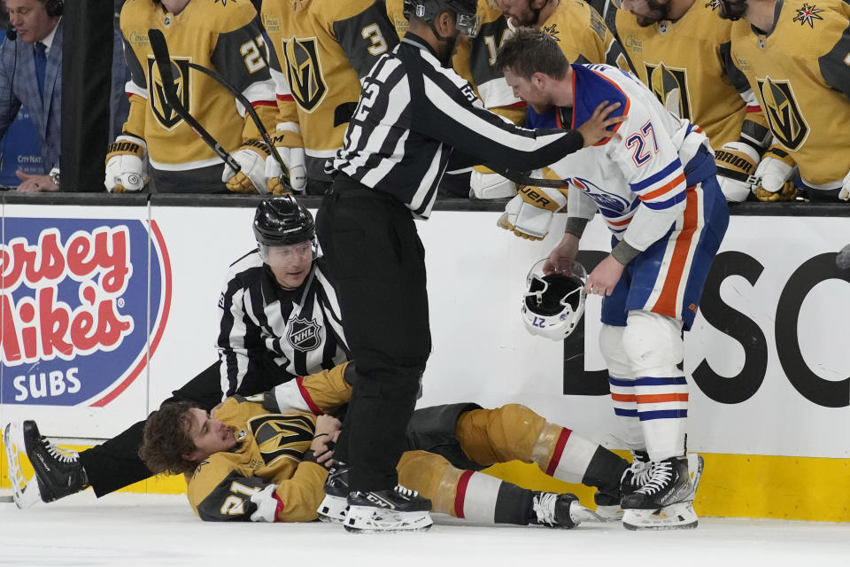 Officials separate Vegas Golden Knights center Brett Howden (21) and Edmonton Oilers defenseman Brett Kulak (27) during the second period of Game 2 of an NHL hockey Stanley Cup second-round playoff series Saturday, May 6, 2023, in Las Vegas. (AP Photo/John Locher)
