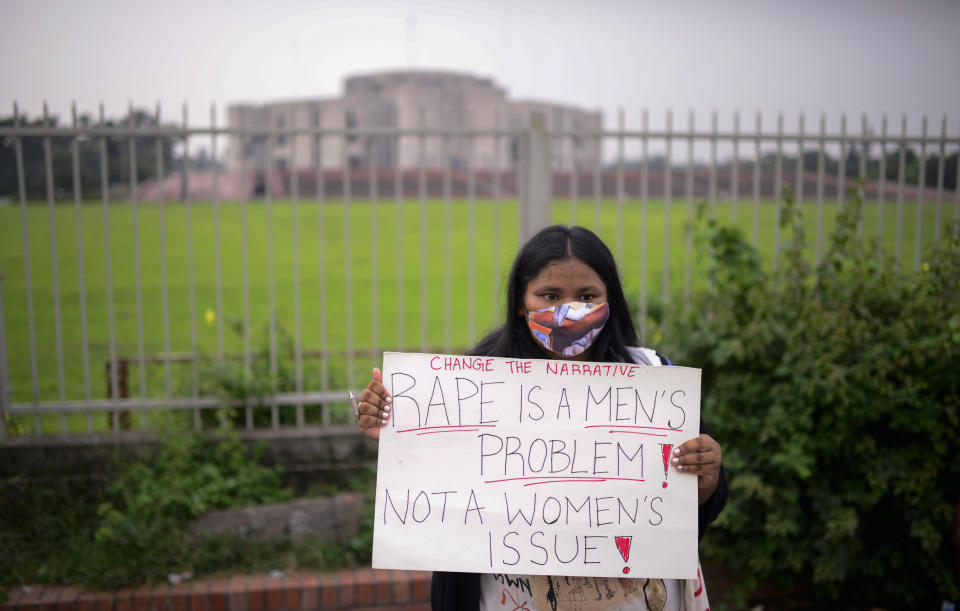 A women’s rights activist among those protesting against gender based violence holds a placard outside the Parliament in Dhaka, Bangladesh, Friday, Oct.9, 2020. Bangladesh's Cabinet has approved an increase in the maximum punishment in rape cases to death from life imprisonment after a series of recent sexual assaults triggered protests. (AP Photo/ Mahmud Hossain Opu)