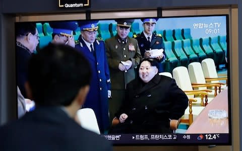 A man watches a TV news programme reporting about North Korea's test-fire of a "new-type tactical guided weapon"  - Credit: AP