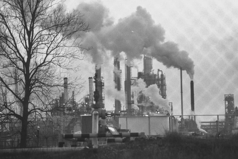 Overall view of large chemical plant w. many tall smoke stacks belching steam laced w. toxic chemicals in an area known as Cancer Alley.