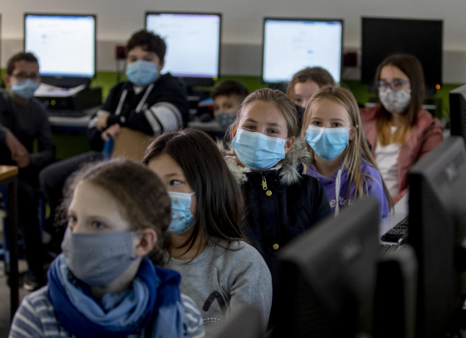 Pupils of a fifth class at a high school wear face masks as they take part in an electronic learning session in Frankfurt, Germany, Wednesday, Oct. 21, 2020. (AP Photo/Michael Probst)