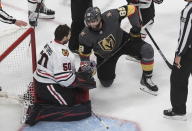 Vegas Golden Knights' Alex Tuch (89) and Chicago Blackhawks goalie Corey Crawford (50) have a laugh after colliding during the third period of an NHL hockey Stanley Cup first-round playoff series, Thursday, Aug. 13, 2020, in Edmonton, Alberta. (Jason Franson/The Canadian Press via AP)