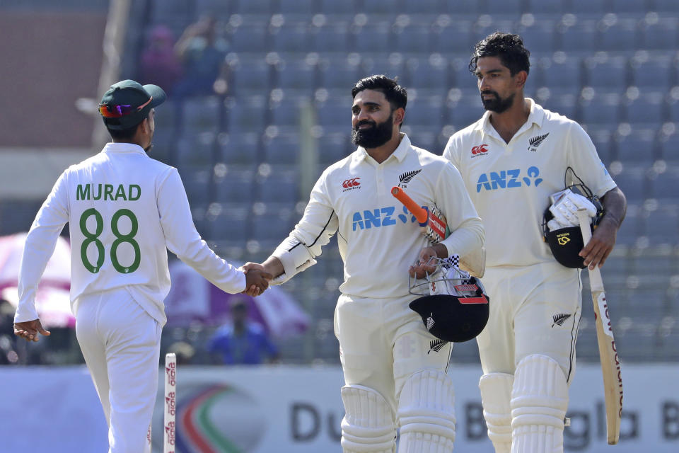 New Zealand cricketerAjaz Patel, center, and Bangladeshi cricketer Hasan Murad shake hands at the end of the fifth day of the first test cricket match at Sylhet, Bangladesh, Saturday, Dec. 2, 2023. (AP Photo/Mosaraf Hossain)