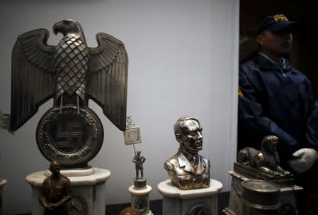 Police officer stands next to Nazi artefacts during a news conference at the Holocaust museum in Buenos Aires