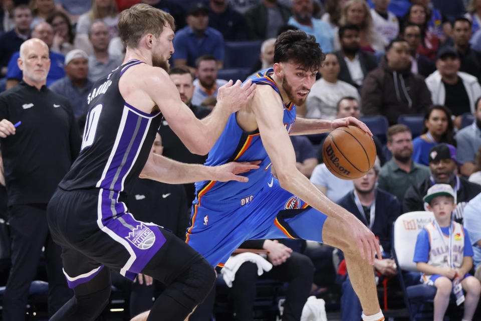 Oklahoma City Thunder forward Chet Holmgren, right, drives against Sacramento Kings forward Domantas Sabonis during the second half of an NBA basketball game Tuesday, April 9, 2024, in Oklahoma City. (AP Photo/Nate Billings)