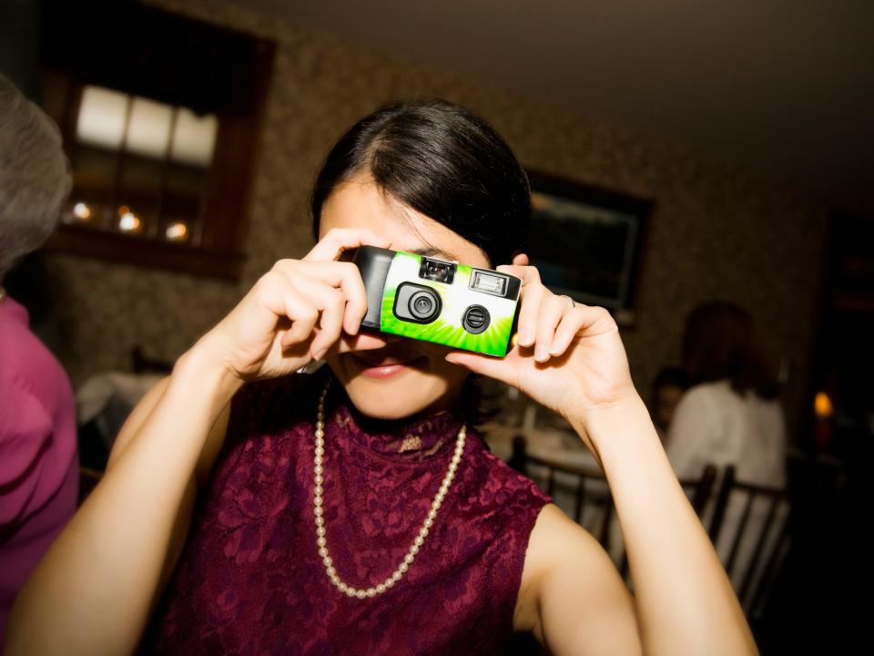 Woman taking photos on a disposable camera.