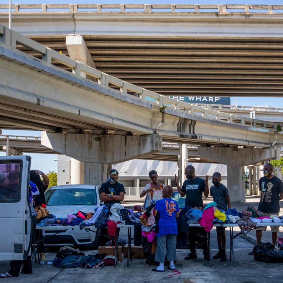 Volunteers help pass out donated clothing and food during a donation and feeding event hosted by The Smile Trust, Inc. near Southwest 2nd Avenue and Second Street in Downtown Miami, Florida, on Sunday, October 17, 2021.