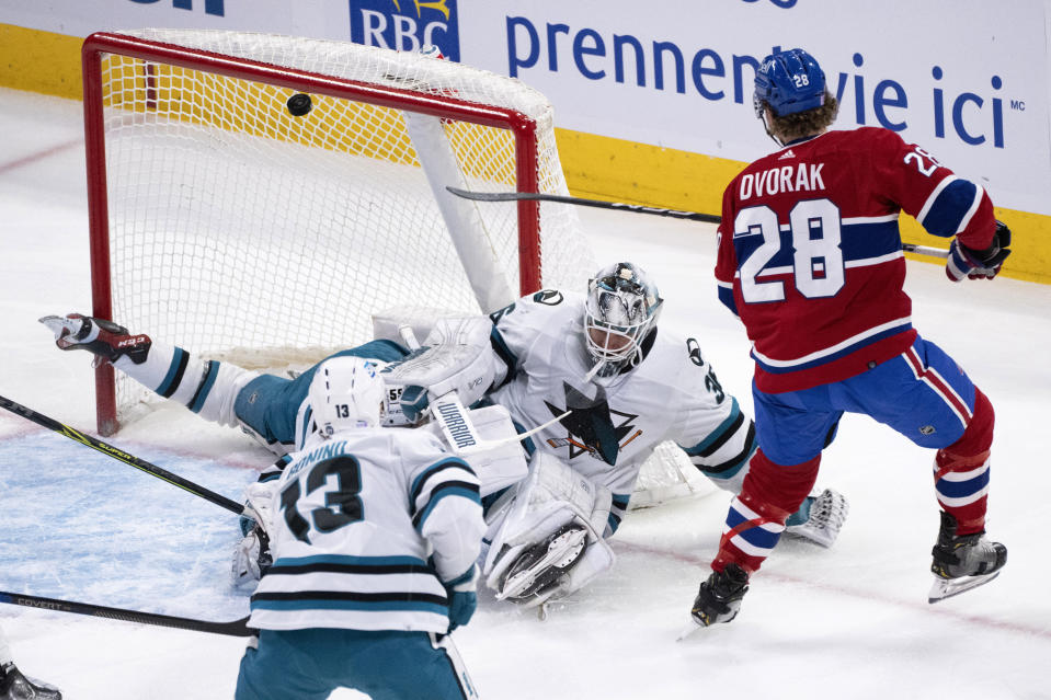 The puck deflects off the crossbar behind San Jose Sharks goaltender Kaapo Kahkonen on a shot by Montreal Canadiens' Christian Dvorak during the second period of an NHL hockey game Tuesday, Nov. 29, 2022, in Montreal. (Paul Chiasson/The Canadian Press via AP)