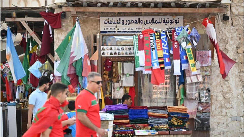 Comercio en Doha con banderas de diferentes países que participan en el Mundial.