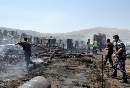 Firefighters put out fire at a camp for Syrian refugees near the town of Qab Elias, in Lebanon's Bekaa Valley, July 2, 2017. REUTERS/Hassan Abdallah