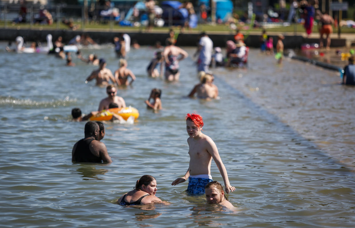 People try to beat the heat at a beach in Chestermere, Alta., Tuesday, June 29, 2021. Environment Canada warns the torrid heat wave that has settled over much of Western Canada won't lift for days. (Jeff McIntosh/The Canadian Press via AP)